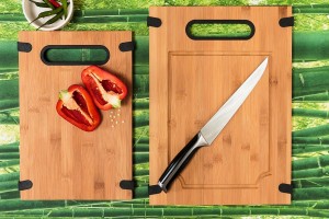chopping board made from bamboo with a halved red pepper and cook's knife