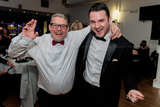 Black-Tie-Event-Photography Corporate event with two men arm in arm enjoying the party atmosphere