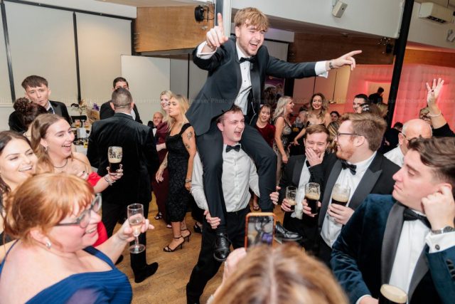Black-Tie-Event-Photography Black tie corporate event with two men enjoying the party atmosphere in the crowd