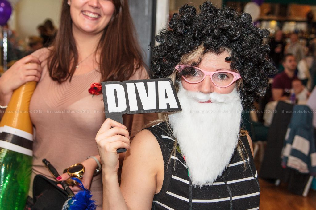 People dressed in wigs and holding funny party props for corporate party photography