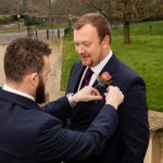 Best man adjusts groom's pocket square