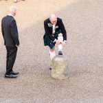 Man in kilt pulling up his socks