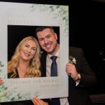 Couple pose with a cut out frame