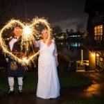 Bride and groom trace a heart with sparklers