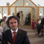 Groom waiting at the front of the church as the bride readies herself to walk down the aisle