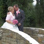 newly married couple share an intimate moment on a bridge