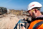 construction worker on a cherry picker looks at his cellphone