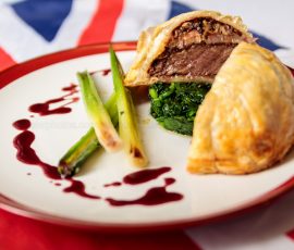 Individual Beef Wellington served with greens and wine jus