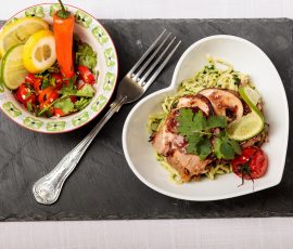 Plate of food shot direct above. The plates rest on a rectangle of slate and a fork lies between the plates