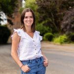 Portrait of young woman standing by a road close to a railway viaduct
